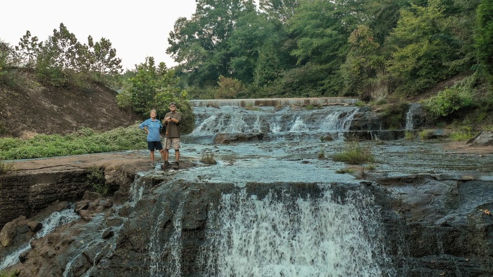couple standing at the top of the waterfall