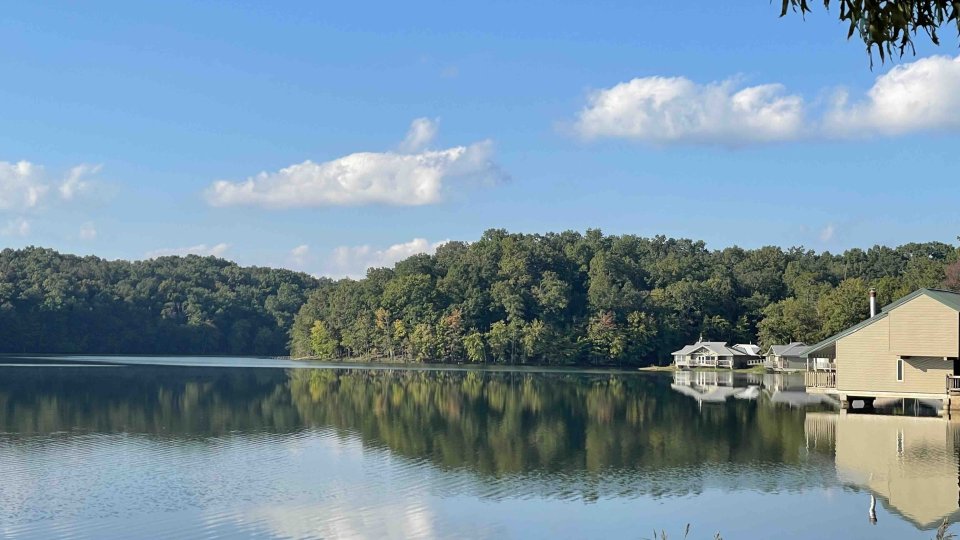 view of lake with trees in the distance and buildings to the right