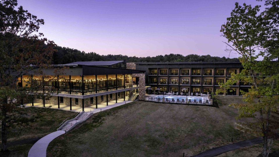 view of lodge outside at dusk with lights turned on