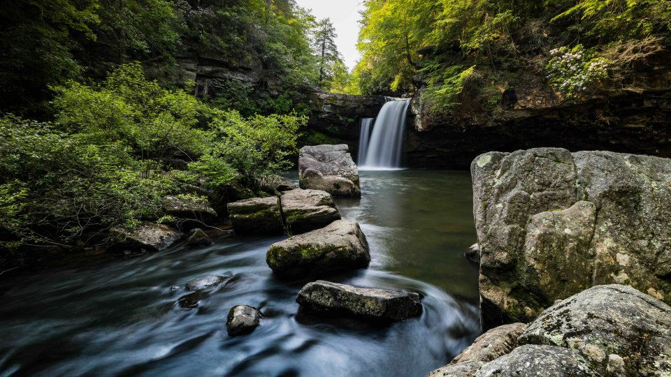 view of rocks and a calm waterfall with small water ripples