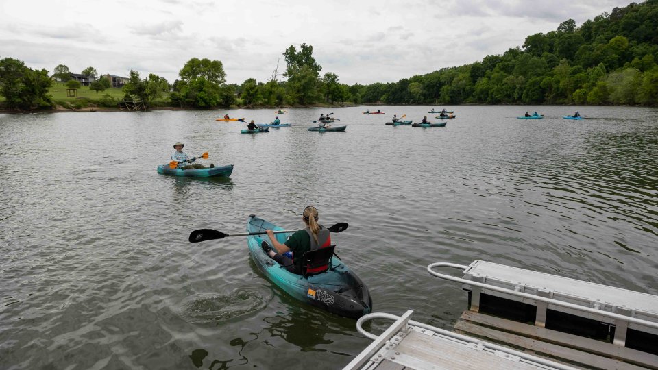 several people using accessibility canoes to paddle in a lake