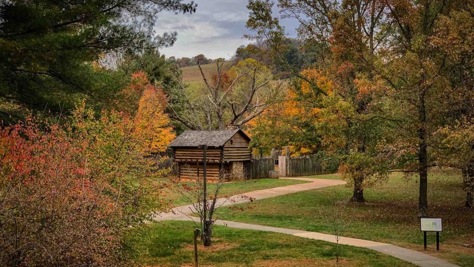 a wooden fort in the fall with paved trails leading to it