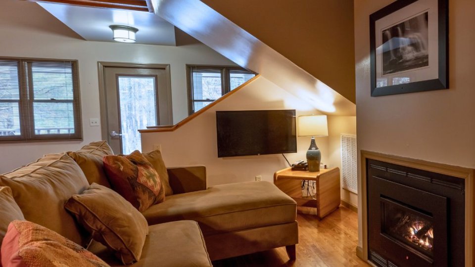 Cozy living room with a fireplace and wooden beams on the ceiling.