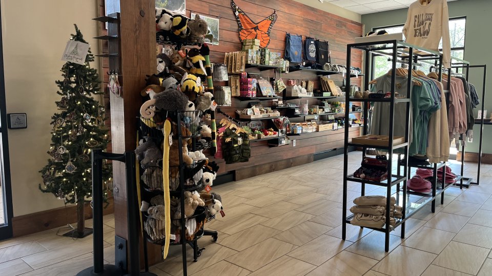 Indoor shop display with plush toys and clothing racks.