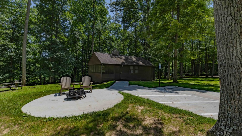 Brown Cabin in the distance with a ADA accessible parking lot and path leading toward it.