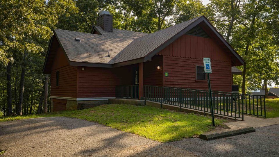 red cabin with handicap parking and a ADA accessible ramp leading to the door