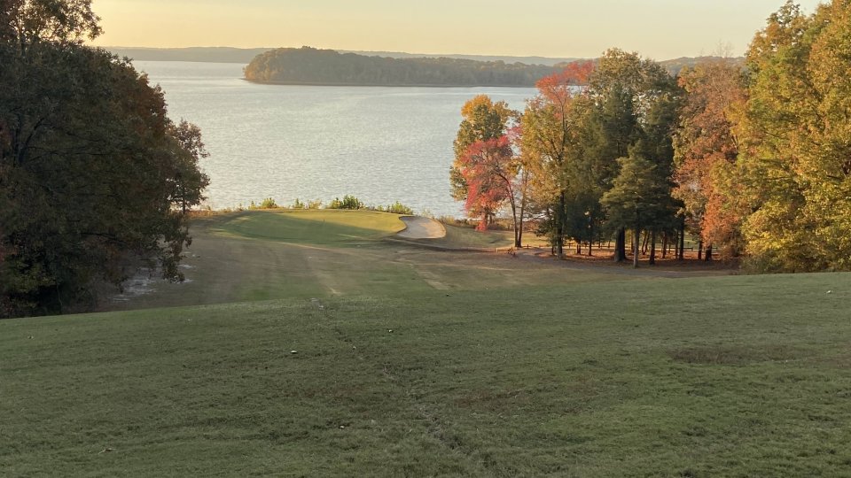 Autumn lakeside view with trees displaying fall colors.