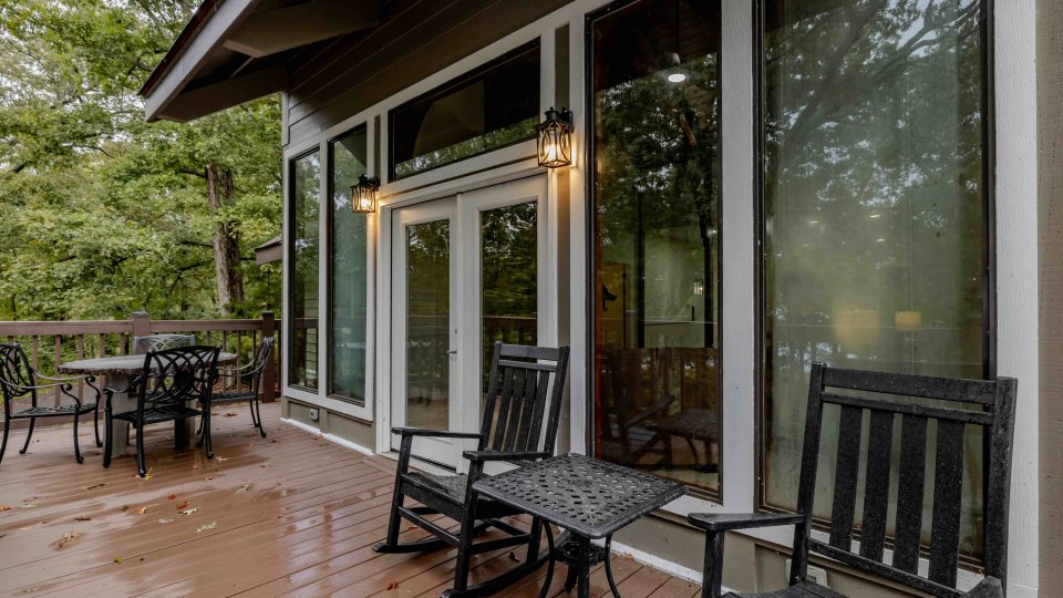 Wet patio with furniture overlooking a forest.
