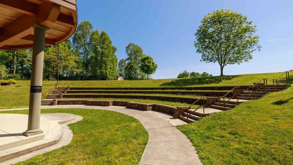 Amphitheater with a concrete path and grass and stone seating.