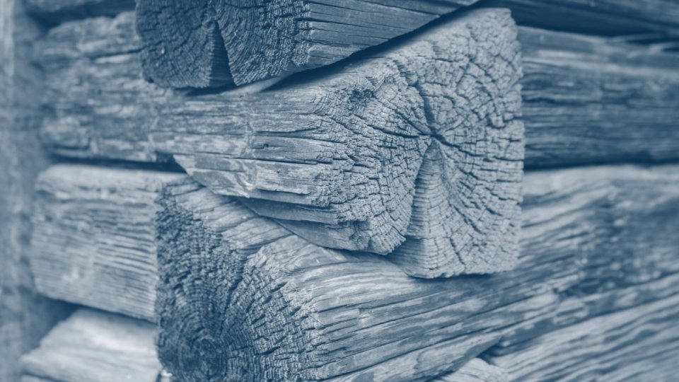 corner of a wooden cabin where the wood fits on top of each other with a blue highlight