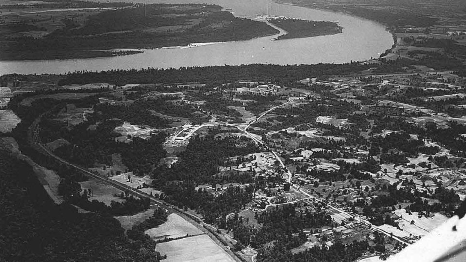 Aerial view of a winding river with surrounding landscape in grayscale.
