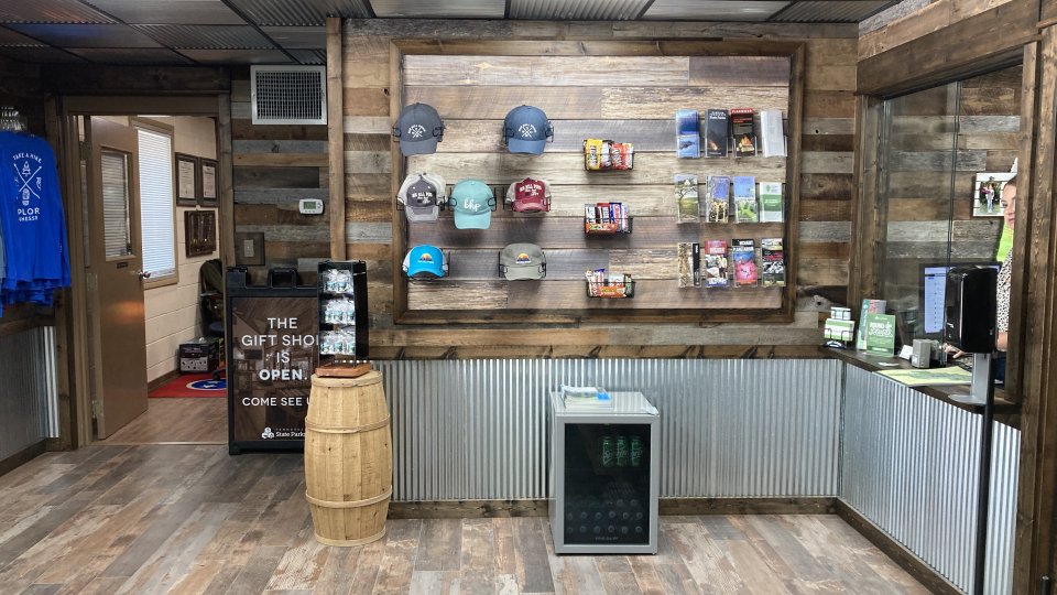Rustic store interior with wooden shelves displaying various products.