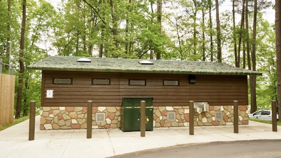 Public restroom building with stone foundation in a park.
