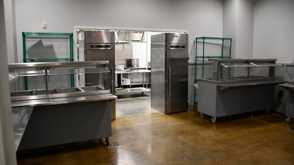Commercial kitchen with stainless steel counters and shelves.