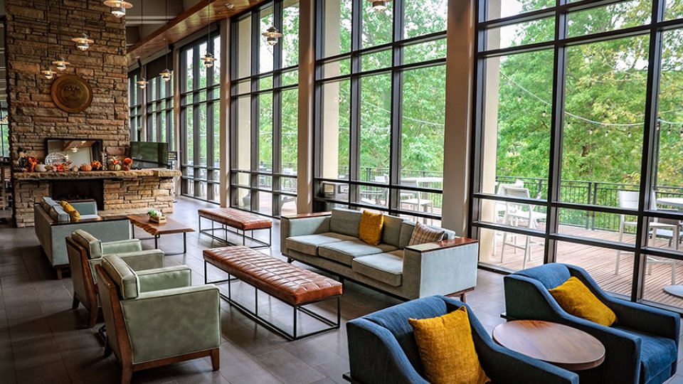 Modern lounge area with large windows, comfortable seating, and fireplace.