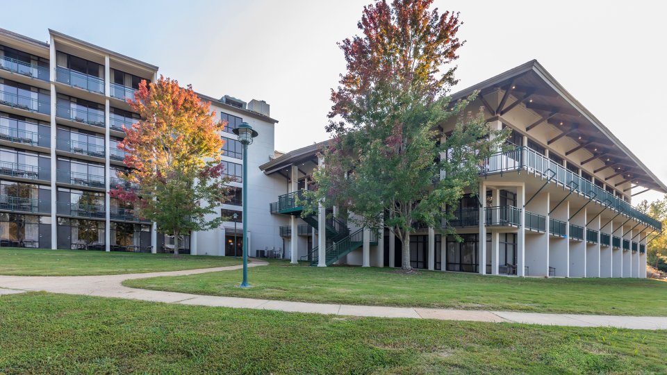 Buildings with autumn trees and green lawn.