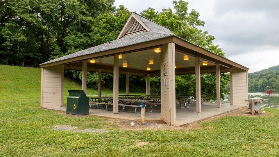 Pavilion Shelter #4 at Warriors' Path State Park, down by the lake, overhead lights are on, picnic tables shown