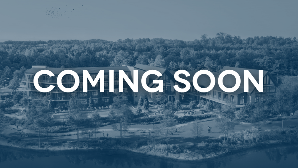 A rendering of the future lodge at Natchez Trace, a large building on the shores of a lake. Overlaid text says "coming soon"