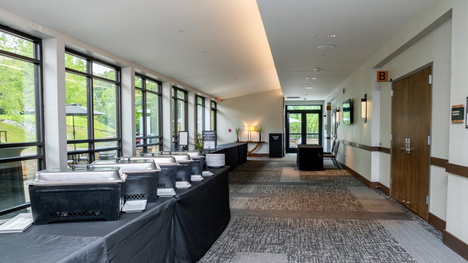 Spacious corridor in a modern building with a catering setup on tables.