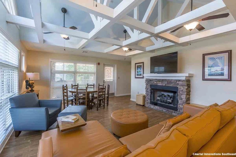 Cozy living room with blue armchair, fireplace, and wooden dining table.