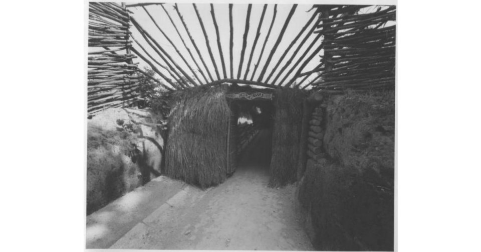 Entrance of a rustic structure with overhead wooden beams.