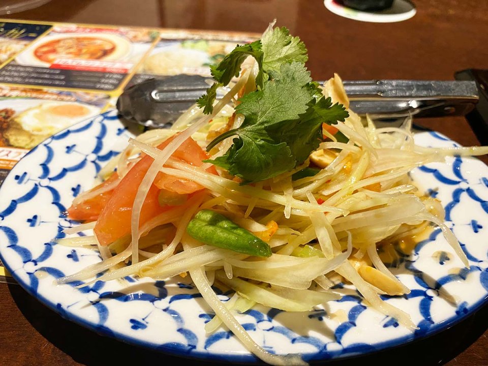 Fresh papaya salad on a decorative blue and white plate.