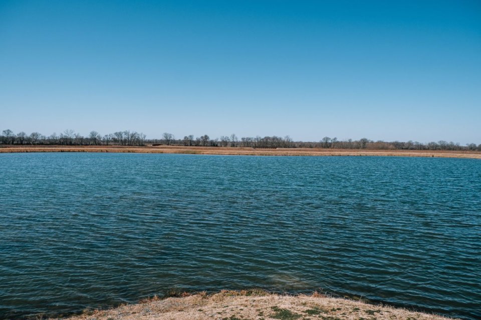 large pond with flat land in the distance