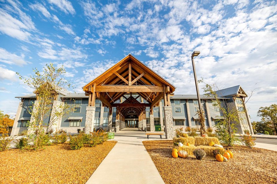 a large building with a wooden covering at the entrance on a sunny day