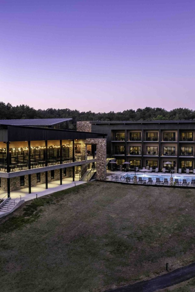 view of lodge outside at dusk with lights turned on
