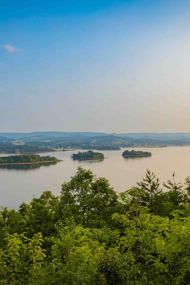 view of multiple small bodies of land on water with the sun beginning to set