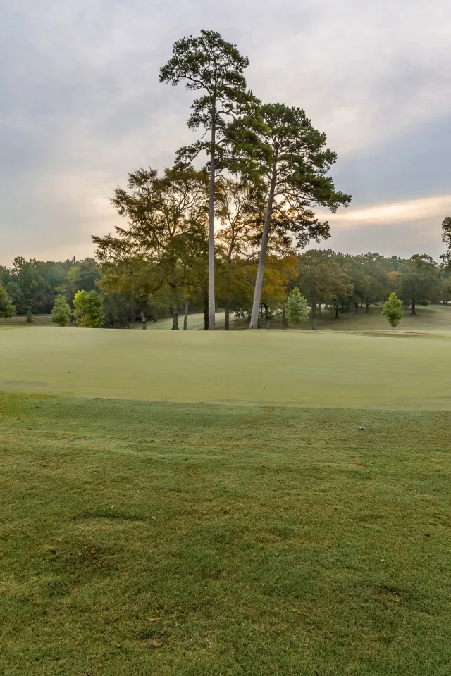 A hole on a golf course at sunset