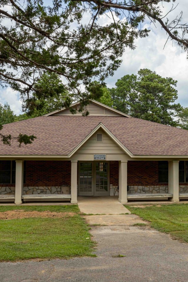 Single-story community center with a brown roof and wrap-around porch.
