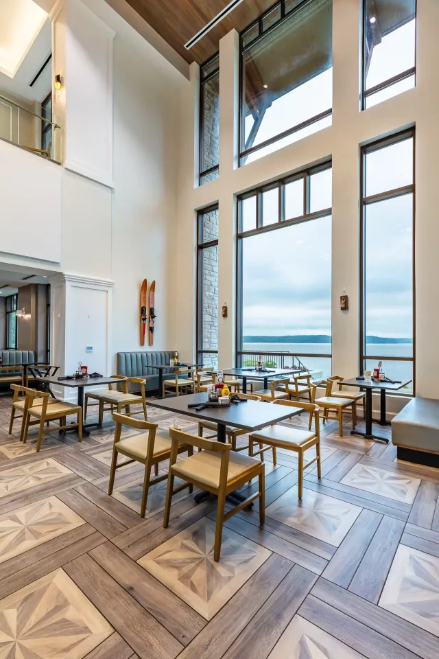 Spacious, modern dining area with large windows and wooden furniture.