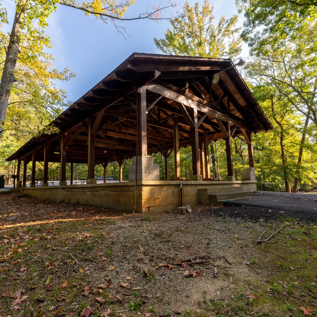 Pavilion surrounded by trees with a concrete path leading to it