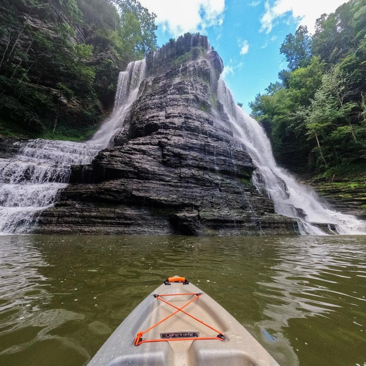 A kayaker near the base of the large Burgess Falls waterfall.