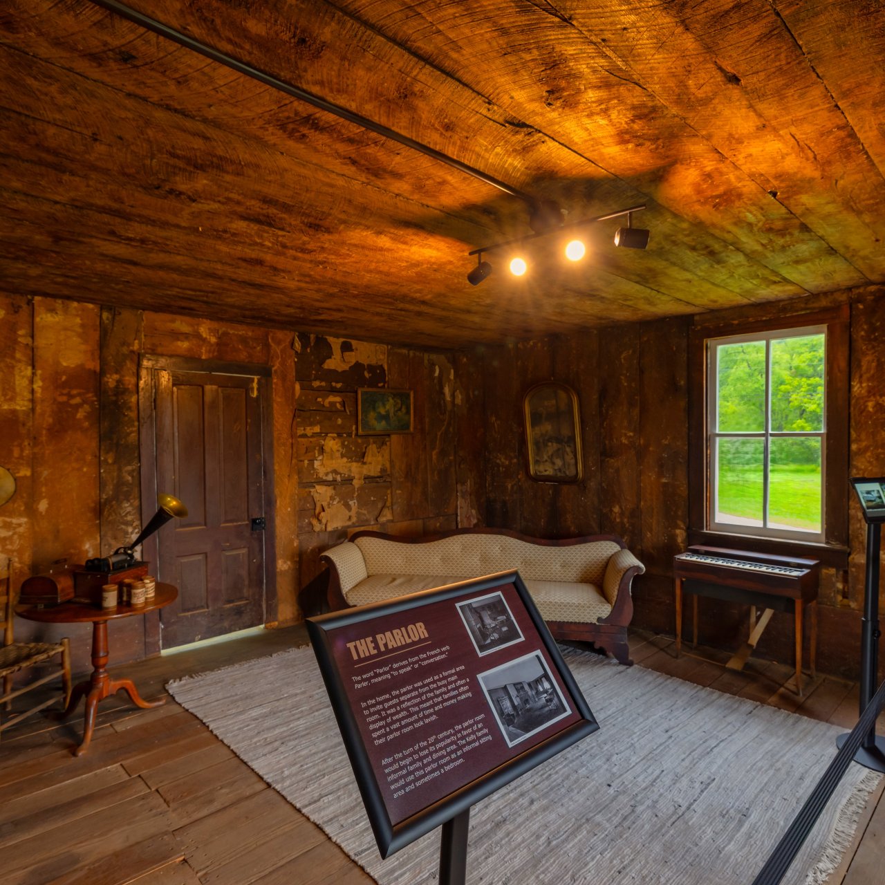 Wooden room with overhead light, sign with historical information and line separators