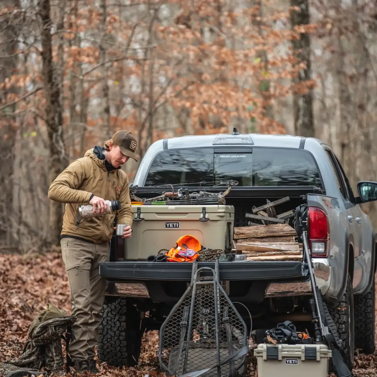 Truck camper parked in a wooded campsite.