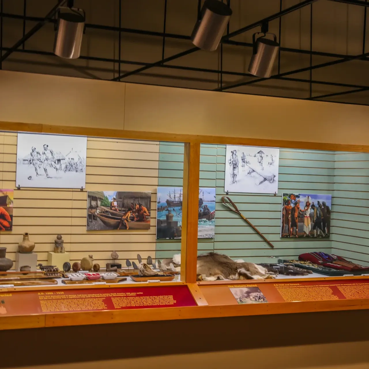 Museum exhibit with artifacts and historical images on display.