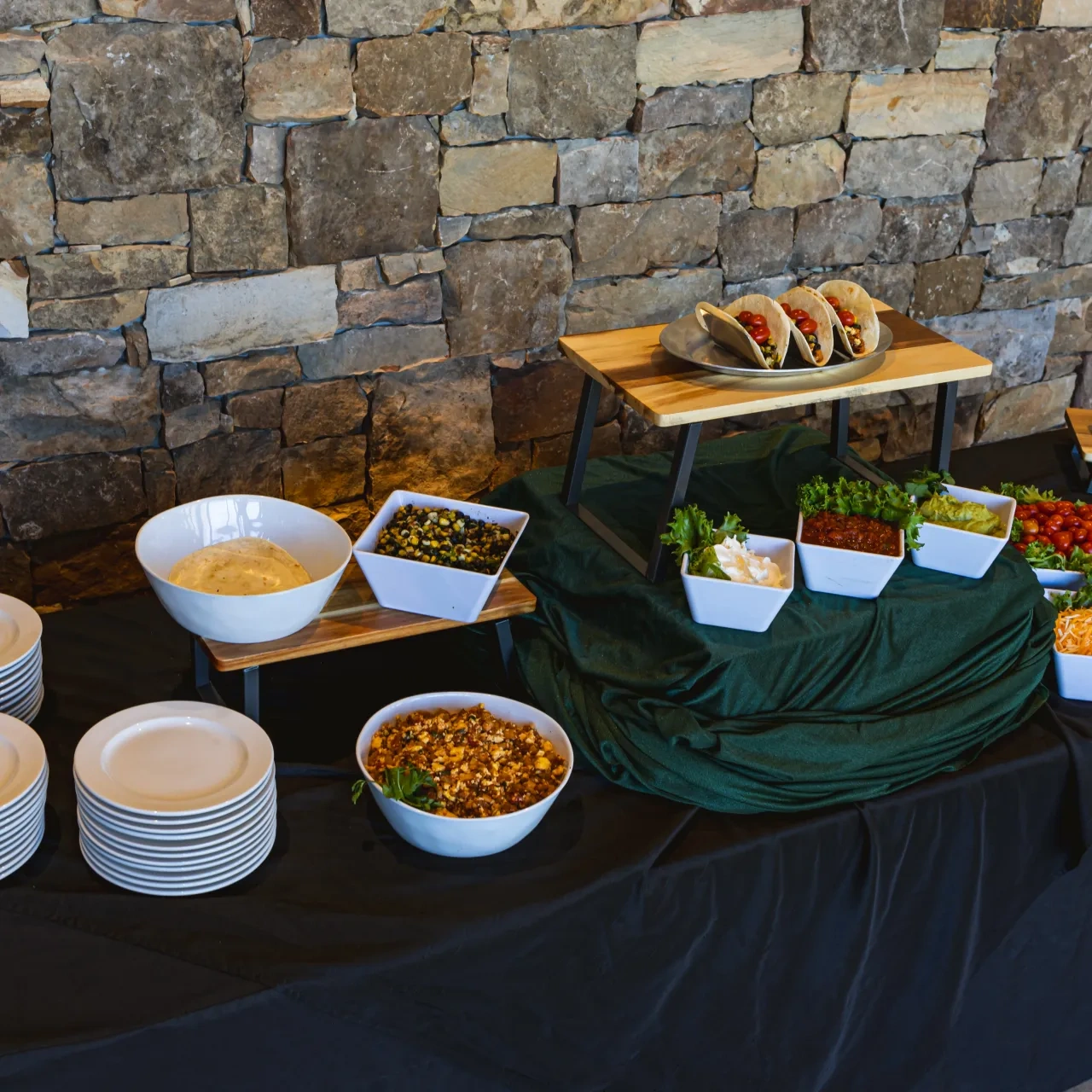 food and plates on a black table cloth organized neatly for catering
