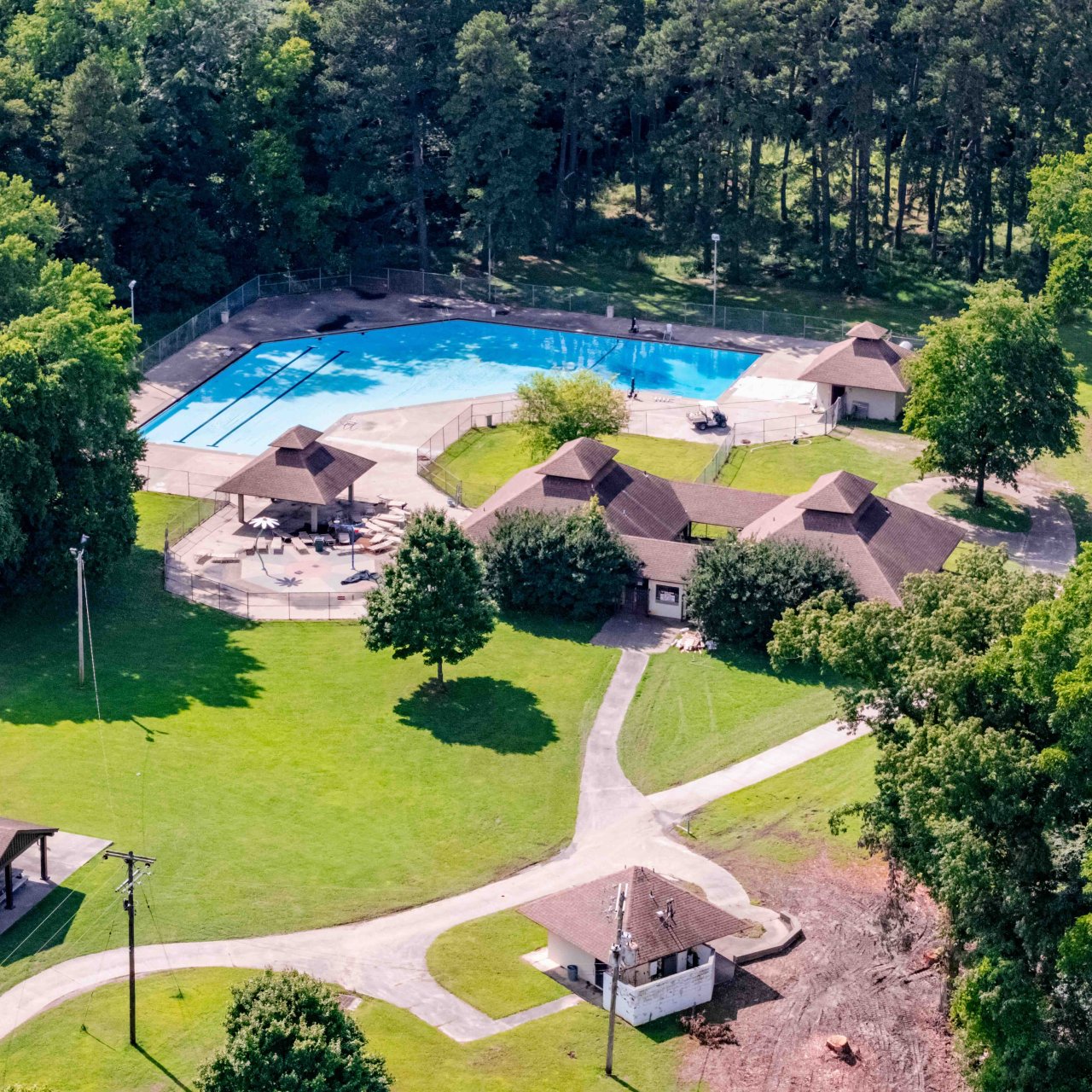 photo taken in the sky of the pool, several buildings, and shelters
