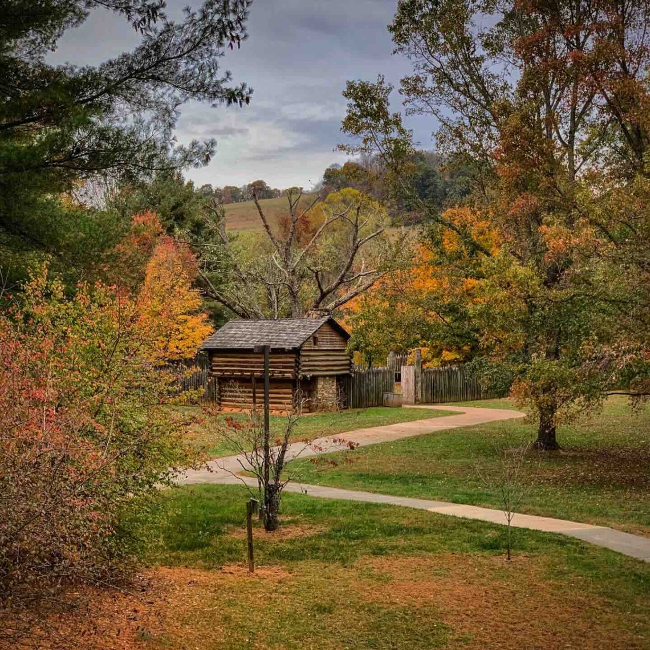 a wooden fort in the fall with paved trails leading to it