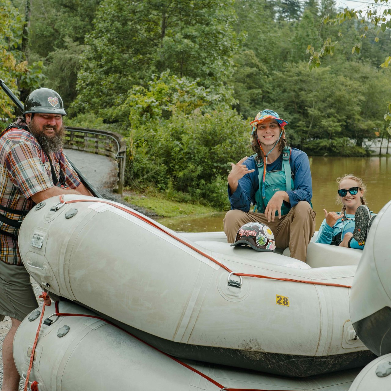 group of white water rafting instructors on and near rafts that are grouped together