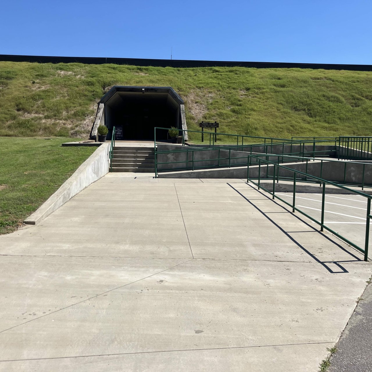 Large concrete area with handicapped parking, accessible ramp, and railing.