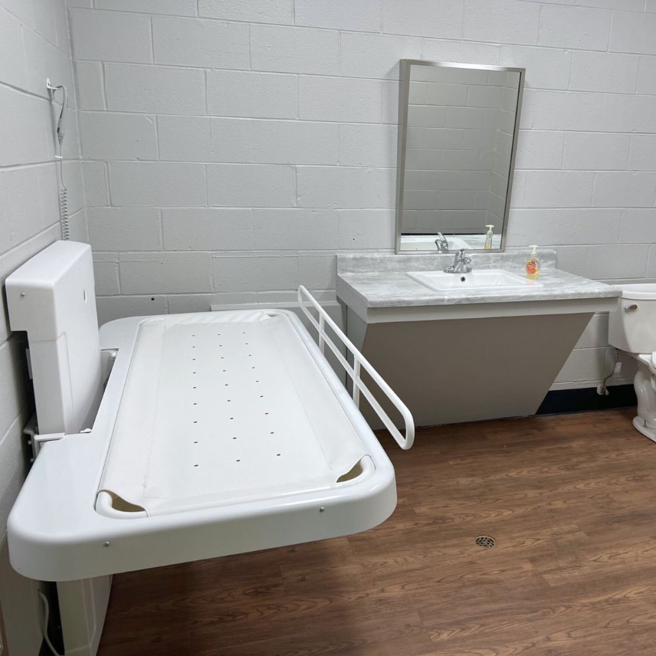 Adult-sized changing table next to a sink.