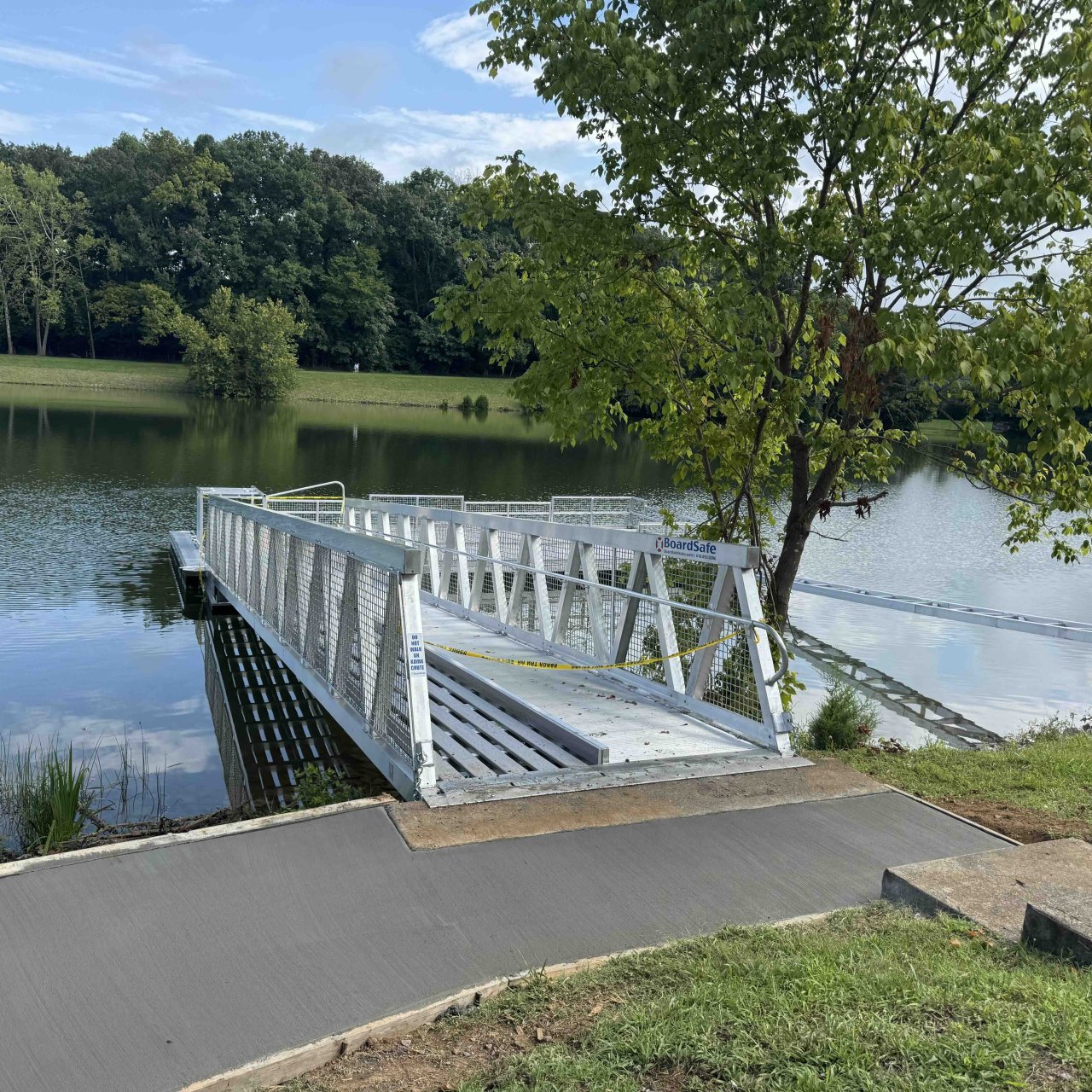 Concrete path going to a metal ramp that leads to a boat launch.